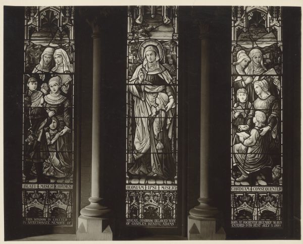 View of a stained glass window trio, depicting women and girls. The memorial reads: "This window is erected in affectionate memory of Abigail Disbrow beloved wife of Charles Kendall Adams born Rochester December 30, 1828. Entered into rest July 5, 1889." The windows also have a Latin inscription: "Beati misericordes quoniam ipsi misericordiam consequitur." (Blessed are the merciful: for they shall obtain mercy. Matthew V:7). These windows are part of Sage Chapel on the campus of Cornell University.