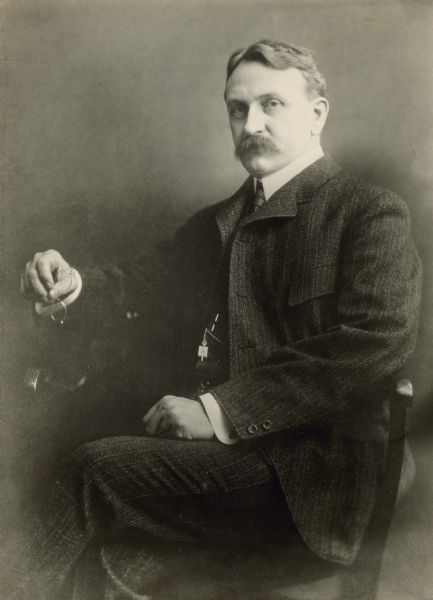 Seated portrait of Henry Carter Adams, a Professor of Political Economy and finance at the University of Michigan, 1880-1921.