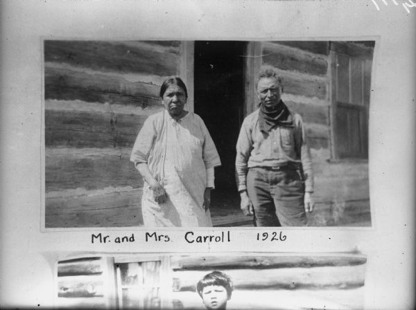 Portrait of a man and woman, standing outside the open door to a log cabin. Caption reads: "Mr. and Mrs. Carroll, 1926."