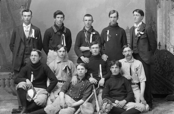 Group portrait in front of a painted backdrop of a high school baseball team.