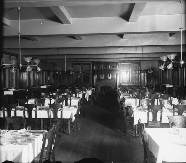 Interior view of the Milwaukee-Downer College dining hall. Places at the tables are set.