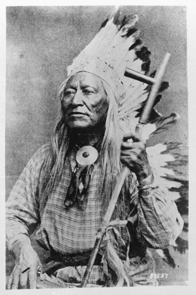 Photograph of a portrait of Shoshone leader Chief Washakie, who is holding a pipe. Caption indicates it is "from a woodcut."