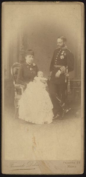 Cabinet card group portrait of Alfonso XII and Maria Christina, the King and Queen of Spain. Queen Maria Christina is holding their first daughter, Maria de las Mercedes.