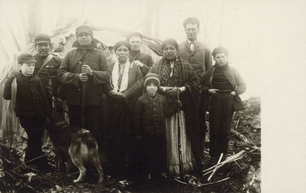 Group portrait of several adults and children. Caption reads: "Winnebago Family and white visitors, 'John Canoe' and his family of two children."