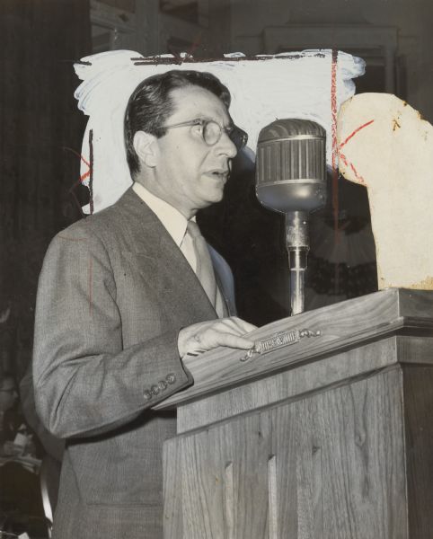 Close-up of a man at a podium. Caption reads: "OPPOSITION to form of CIO structure change was voiced by George Baldanzi. He was lone objector."