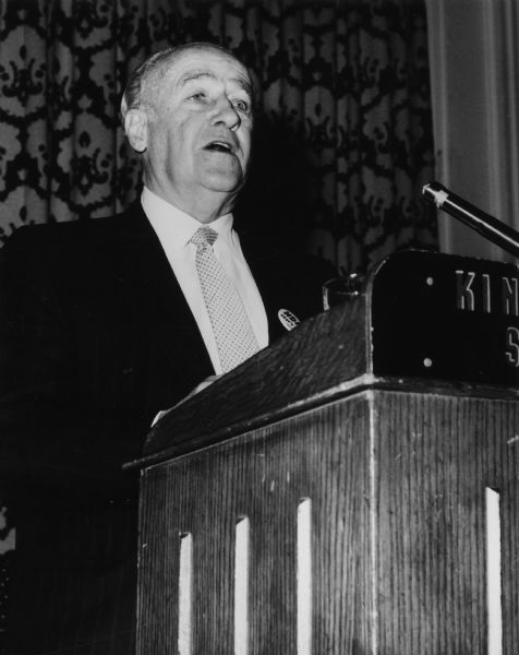 A man stands at a podium. Caption reads: "General President William Pollock defends international unions at TWUA's 10th Biennial Canadian Conference."