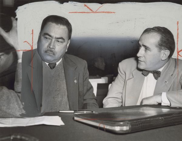 Two men are seated at a table. One is looking at the other. Caption reads: "TEXTILE LEADERS met at Western hemisphere conference of International Confederation of Free Trade Unions in Mexico City last month. On left is Francesco Marquez of CTM [Confederación de Trabajadores de México], Mexican textile union. On right is TWUA [Textile Workers Union of America] General Secretary-Treasurer William Pollock.