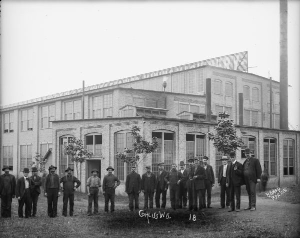 Several men posing in front of the newly constructed Brown Corliss Engine Co. machine factory. Caption reads: "Corliss, Wis. About 1901. Men in front of machine factory."