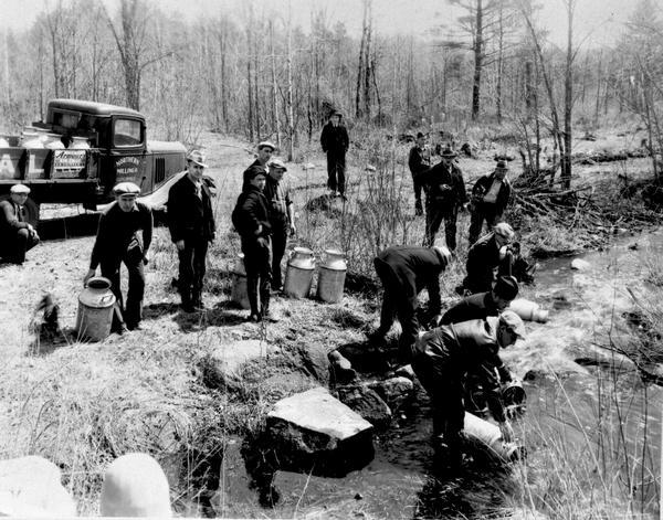 Planting trout in Waupaca County. Left to right on bank: S.A. LaVoilette, Joe Samz, Lloyd Pinkawski, Edwin Kargewski, W.M. Geiger, G. Moder, Billy LaVoilette, Sliff Graff, Roy Peterson, G. Graff-President of Club. Left to right in stream: G.A. Stevens-Secretary of Club, Art Hanley, Hub Stuge, John Allen.