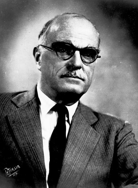 Quarter-length studio portrait of Thornton Wilder wearing eyeglasses.