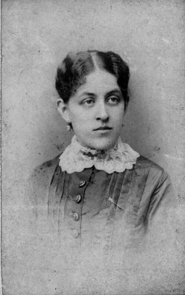 Quarter-length vignetted studio portrait of Carrie Lane Chapman Catt when she was still single and a teacher in Mason City, Iowa.