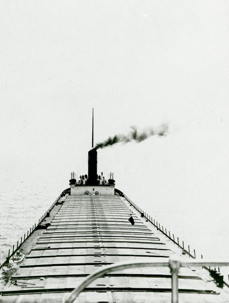 Lake Michigan freighter with smoke billowing from smokestack.  View from from bow looking back toward stern.