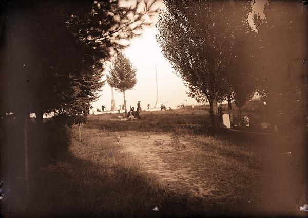 People in a cemetery. Includes a view of the Scofield family monument.