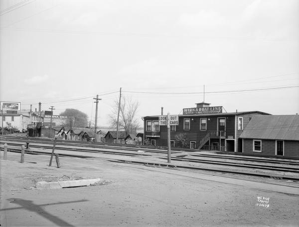 Boathouses on Lake Monona looking southeast from E. Wilson Street across CNW railroad tracks. View of Wirka Boat Line, E. Wilson Street at S. Hancock Street, and Monona Coal Company, 330 South Blair Street.