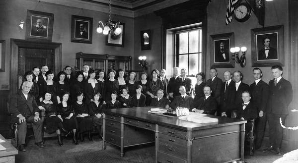 Members of the Department of State in the Governor's office at the Wisconsin State Capitol. Seated, in the middle, is Secretary Fred R. Zimmerman.