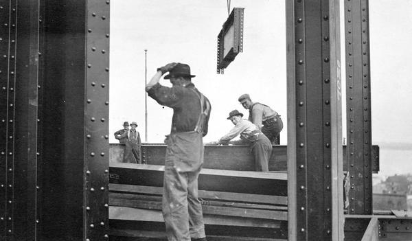 Men doing structural steel work on the Wisconsin State Capitol while under construction.