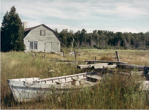 Shore scene at end of Main Road showing studio and small boats at low water.