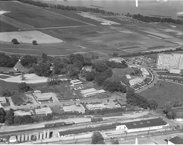 Aerial photograph showing the J.S. Timlin Lumber Company, 2702 University Avenue, as well as Doctors Park, the Veterans Hospital, and the First Unitarian Society, and University Bay Drive. Lake Mendota can be see in the background.