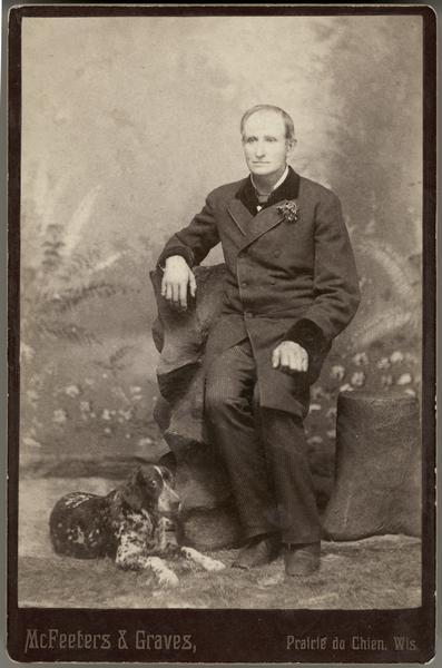 Full portrait of Louis LeBrun with dog at his feet.  Hercules Dousman brought LeBrun from Canada as an indentured servant in 1852.  After completing his indenture, he stayed with the family for more than 50 years.