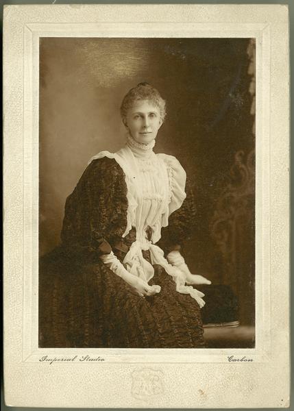 Seated portrait in front of a painted background of a young woman with the notation: "from cousin Lora." Unknown relationship to the Dousman family.