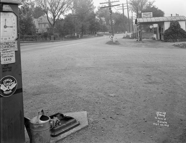 Gas station in a Trachte building on the corner of Highway 51 (Monona Drive) and Highway 30 (Cottage Grove Road). A "Johnson Winged 70 Gasoline" pump is in the foreground of Jack Dvorak's gas station.