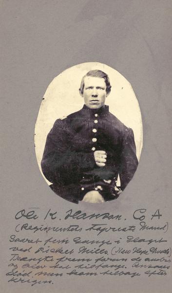 A seated waist-up studio portrait of Ole K. Hanson, a sergeant in Company A, 15th Wisconsin Infantry in uniform.  The following information was obtained from the Regimental and Descriptive Rolls, Volume 20: He held residence in Madison, Wisconsin.  On October 15, 1861 he enlisted in Chicago, Illinois and on November 15, 1861, he was mustered into service in Madison, Wisconsin.  From September to October 1862 he served as Wagon Master.  On May 27, 1864, during the fighting on Altoona Mountain near Dallas, Georgia (New Hope Church), he was listed as missing in action when he was left on the field and taken prisoner.  He did not muster out with A Company.