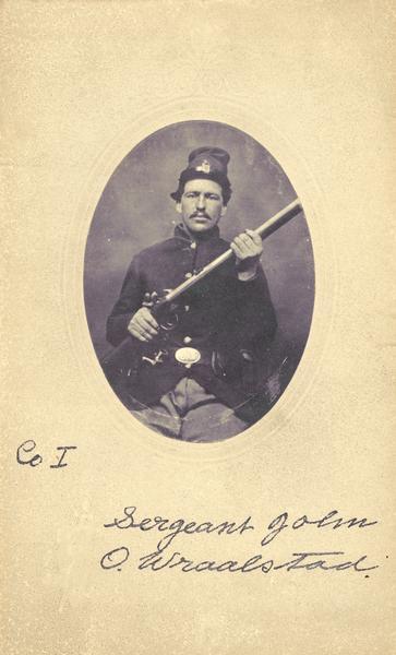 Tintype (ferrotype) portrait of Sergeant John O. Wraalstad, Company I of the 15th Wisconsin Volunteer Infantry, Wisconsin's so-called Scandinavian Regiment. He is posing in a Union uniform and cap, holding his rifle, with a bayonet at his belt. Hand-coloring on cheeks and buttons. 