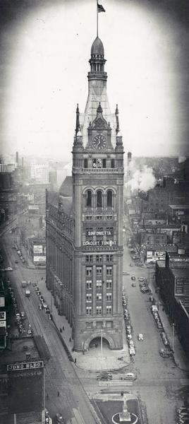 Elevated view of Milwaukee's City Hall. Signs on the building read "Sinfonietta" and "Concert Tonight."