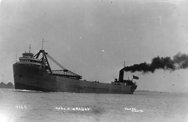 A bow view of the screw bulk freighter, "Carl D. Bradley," underway. Black smoke is pouring from smokestack.