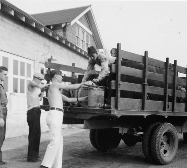 Men loading back pumps and fire fighting equipment onto a truck at Park Falls Ranger Station in preparation for answering a forest fire call.