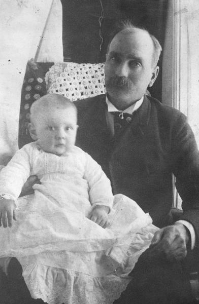 Portrait of Robinson D. Pike of Bayfield seated with baby.