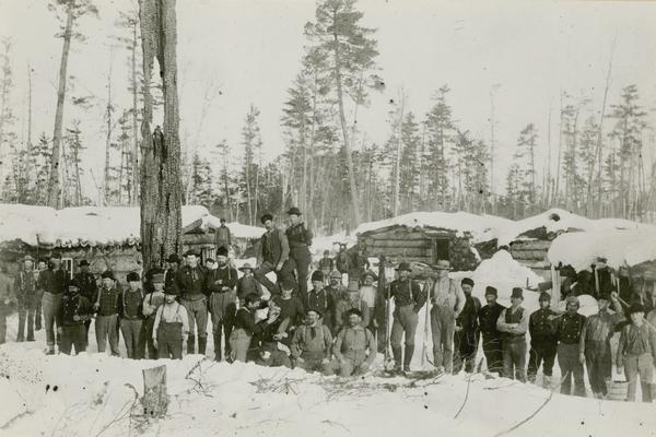 Logging crew posed in front of the buildings of D Sulivan's logging camp near Antigo, Wisconsin.
