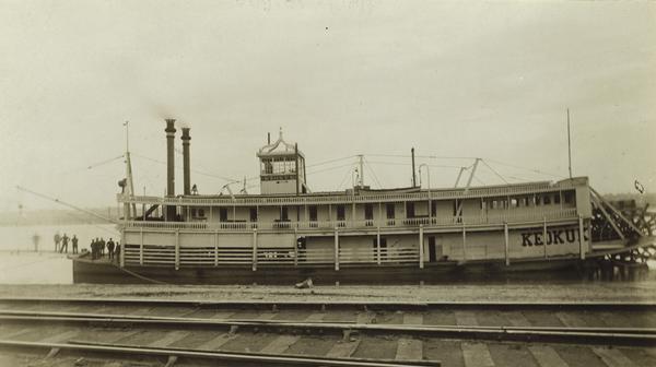 The sternwheel packet, <i>Keokuk</i>, at landing with railroad tracks in foregroun. Between 1907 and 1926.