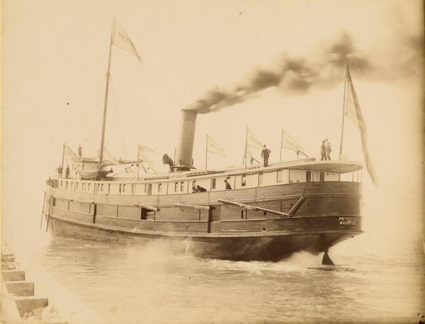A stern side view of the screw passenger and freight vessel, <i>Petoskey</i>, underway. Sign on ship reads Petoskey, Manistee.