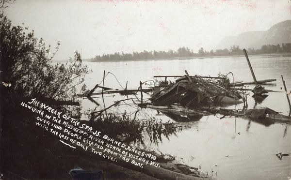 The wreck of the sternwheel excursion, <i>J.S.</i>, after being destroyed by fire on June 25, 1910, now lying in the Mississippi River north of Victory, Wisconsin. Over 1,100 people escaped from this boat, with the loss of only two lives.