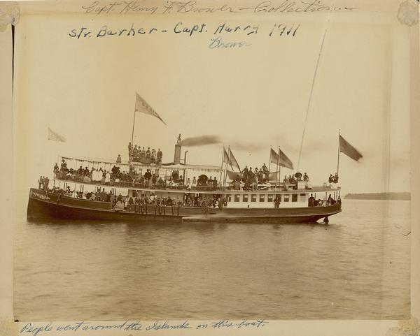 The steamboat "Barker" with numerous passengers posing on deck. The boat was owned by Captain Frank Brower of Ashland, and his son Captain Henry F. Brower was her captain. This steamer was used to tour the Apostle Islands.