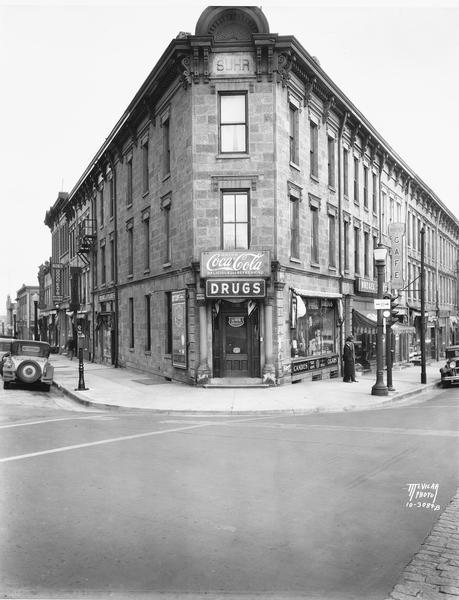 This building on the corner of Main Street (to the left) and King Street (to the right) was built for John J. Suhr and designed by John Nader. Here it houses Dettloff's Pharmacy, as well as Huegel Hyland and Boese's Cafe, 113 E. Main Street.