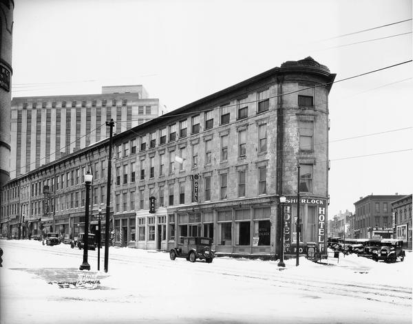 Exterior view of the Sherlock Hotel, 124 King Street at the corner of Doty Street. Snow is on the ground.