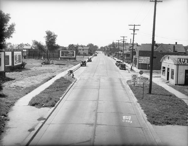 Looking south from railroad viaduct toward Greenbush. View is down newly widened and paved Park Street. The Roman Tavern, 46 North Park Street and Automobile Salvage, 102 N. Park Street (Trachte building) are on the right, with a group of people having a picnic under a tree on the left.