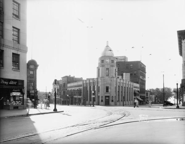 The Wisconsin State Employment Office, formerly the Capital City Bank, located on the corner of King and South Pinckney Streets. On the left is Liggett's Drugstore, 29 S. Pinckney, in the first floor of the Tenney Building.