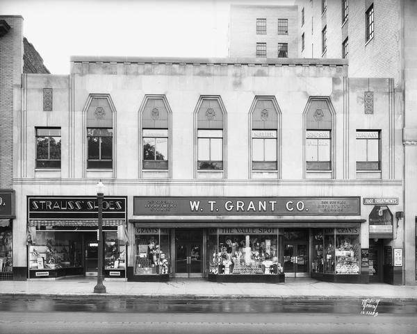 Art Deco building housing Strauss's Shoes at 19 S. Pinckney Street, and the W.T. Grant Company Department Store, located at 21-23 S. Pinckney Street on the Capitol Square. Mueller-Simpson Co. Tailors is on the second floor.