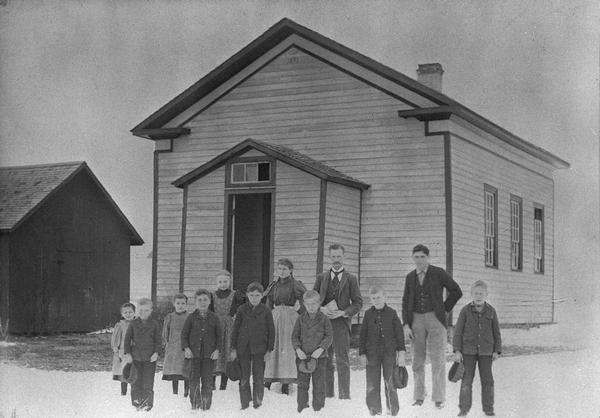 Students and teachers pose in front of Inch School.