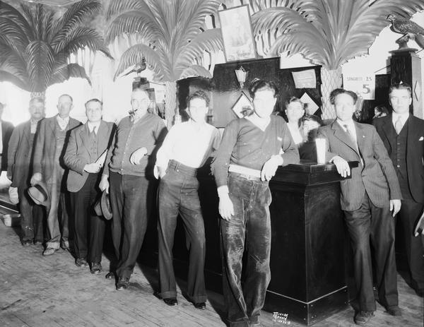 Eight men are posing around the bar in Urso's West Side Palm Tavern. The bar was located at 734 West Washington Avenue in the Greenbush neighborhood.