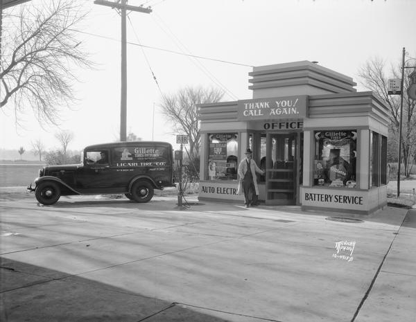 A driver is sitting in Licari's panel truck, next to the small art deco office of Licari Tire Company, where another man is posing at the door, 767 West Washington, in the Greenbush neighborhood.