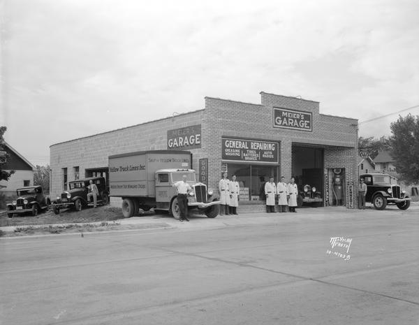 Meier's Garage, located at 1313 Regent Street. The garage did general repair, as well as greasing, washing, and auto radios. Eight employees are in front with a Yellow Truck Lines Inc. truck.