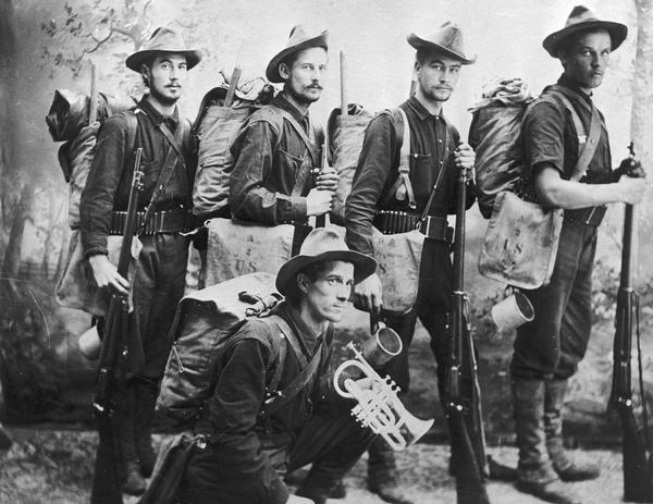 Men from Wisconsin Rapids who bore arms against Spain in the Spanish-American War. From left to right in front of a painted backdrop are Charles N. Laramie, "Patsy" Podawilitz, Earl Ridgemen and Fred Brahmstedt. Arthur J. Houston is kneeling.