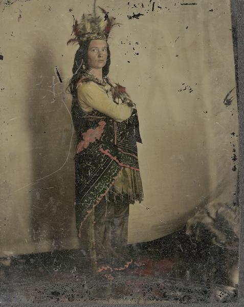 Actress standing with crossed arms dressed in Indian headdress and wrap for performance of "Black Hawk, or Lily of the Prairie," written by Mary Elizabeth Mears (aka Nellie Wildwood) and presented in Madison, Wisconsin in 1857.