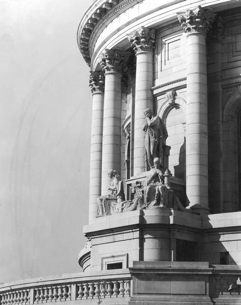 Three ornamental sculptures on the base of the Wisconsin State Capitol dome.