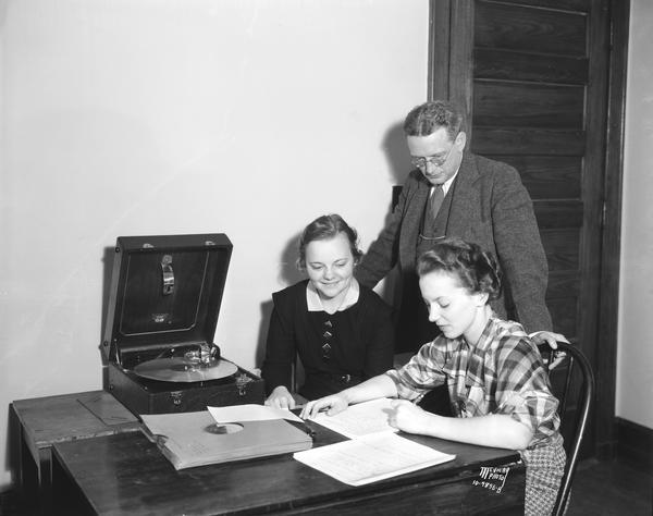 University of Wisconsin Professor Miles L. Hanley watching coeds Laura Severson and Theressa Fein, while they are working on transcriptions for a linguistic atlas of the United States.