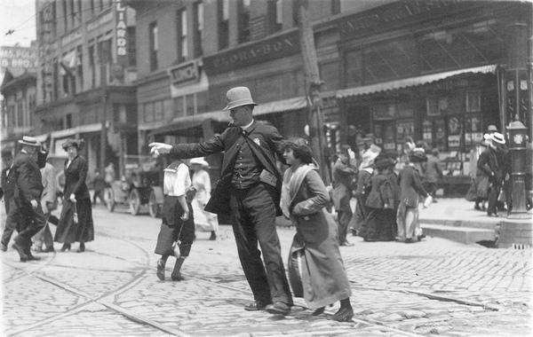 Police officer helping a young woman cross the street.